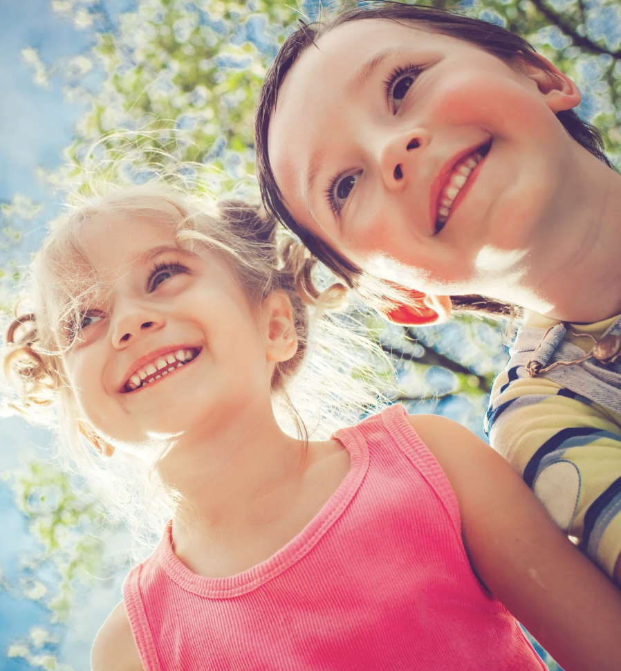 Two children happy and smiling demonstrating how good it feels to be in tune with their emotions through somatic awareness.